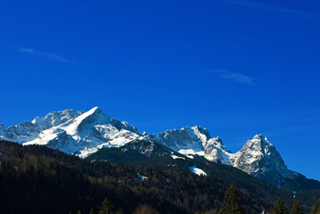 Mountain panorama of the snow-covered Wetterstein mountains in spring, with Alpspitze on the left,...