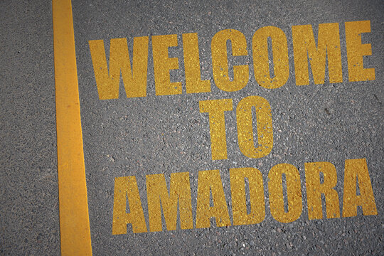 asphalt road with text welcome to Amadora near yellow line.