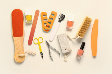 Set of professional tools for pedicure with nail polishes on beige background