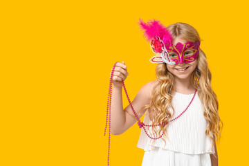 Adorable little girl wearing carnival mask on yellow background - obrazy, fototapety, plakaty