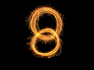 Alphabet and Number eight sparklers on black background by light painting.number 8 sparkling golden...