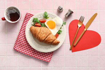 Plate with tasty fried egg, croissant, tomatoes, arugula and cup of coffee on light tile background