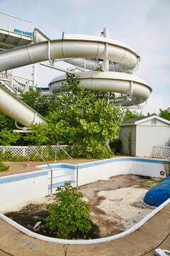 Abandoned Water Park with Overgrown Slide and Empty Pool