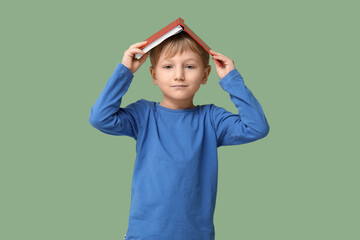 Little boy with book on green background