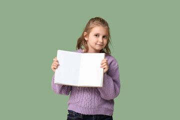 Little girl with book on green background