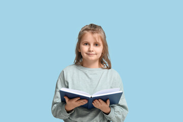 Little girl reading book on  blue background