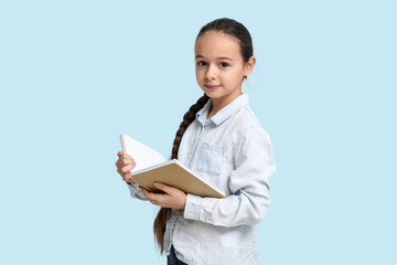 Little girl reading book on  blue background