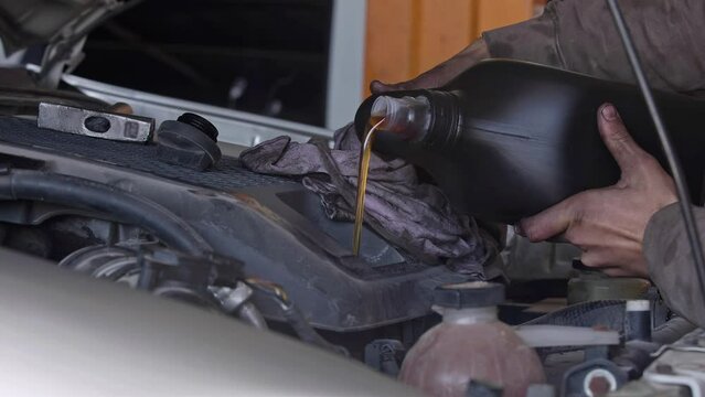 Pouring New Engine Oil in Car Repair Shop Footage.