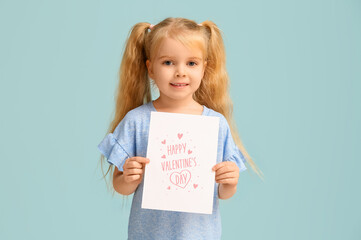 Cute little girl holding greeting card with text HAPPY VALENTINE'S DAY on blue background