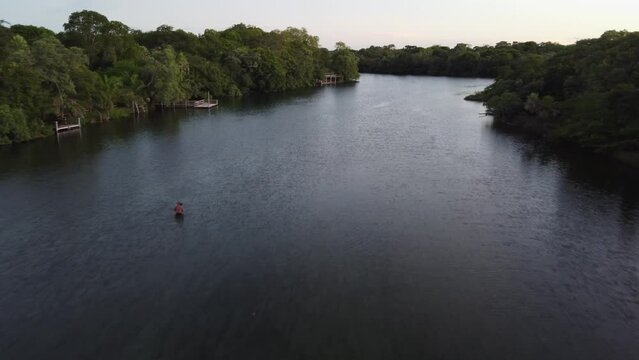 Low flight down shallow jungle river, dense forest in central Bolivia