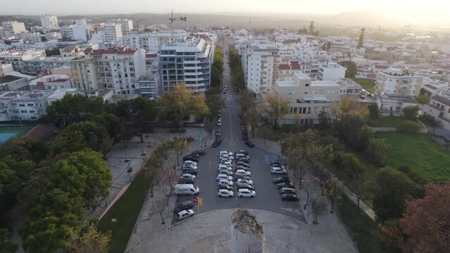 Drone flying backwards revealing Engineer Duarte Pacheco's Monument with Loul&eacute; cityscape in Background