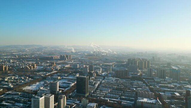 Aerial perspective on a winter day during the enchanting sunset in Zibo City, Shandong Province, China, unveiling a captivating scene with the silhouette of power plants in the background.