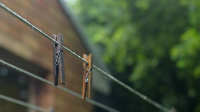 Wooden pegs hang on clothesline after rain