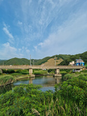 
It is a riverside with a railroad bridge.