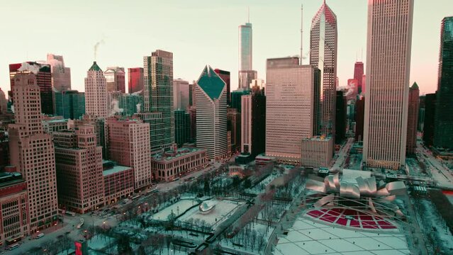 Jay Pritzker Pavilion in snow.  Panormaic aerial of Chicago center. Cinematic sunset - great for opening shot.
