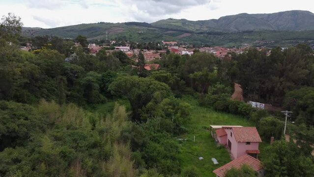 Low aerial flight over lush jungle to mtn town of Samaipata in Bolivia