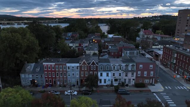 City rowhomes in USA at dusk. Aerial flight over urban houses at night.