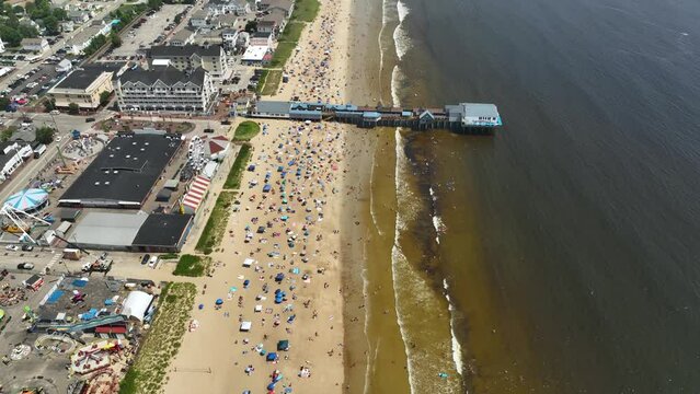 Drone shot of Maine's crowded Old Orchard Beach on a sunny day.