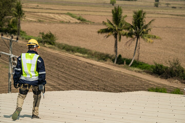 Engineer walking at roof top of warehouse industry at urban rural. Worker operating for inspection and construction.