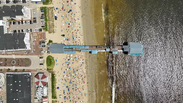Overhead view of the Old Orchard Pier in Maine with crowded beaches.