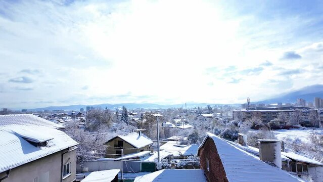 walking out on the balcony to discover a snow-covered rooftops on a cold winter day