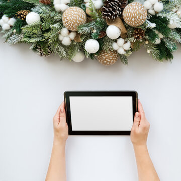 Christmas composition and women hands holding tablet pc.