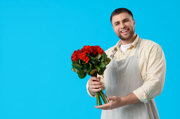 Male florist with bouquet of flowers on blue background