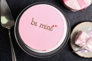 Stand with pink bento cake and gift boxes on black grunge background. Valentine's Day celebration