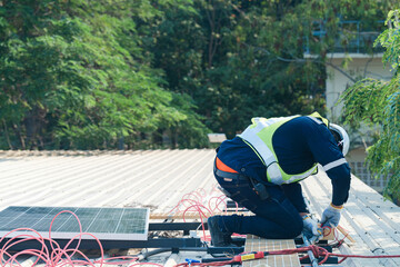 Worker Technicians are working to construct solar panels system on roof. Installing solar photovoltaic panel system. Men technicians carrying photovoltaic solar modules on roof.