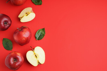 Fresh red apples and leaves on color background