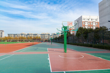 In the school yard:a basketball stands and school building.