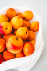 bunch of fresh apricots straight from the farmers' market in plastic bag