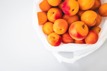 bunch of fresh apricots straight from the farmers' market in plastic bag
