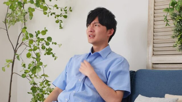 自宅で手うちわをする男性