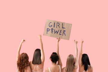 Beautiful young women holding paper with text GIRL POWER on pink background, back view. Women...