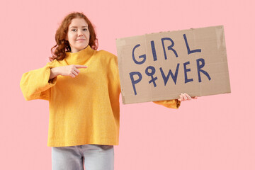 Beautiful young woman pointing at paper with text GIRL POWER on pink background. Women history month