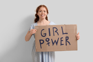 Beautiful young happy woman holding paper with text GIRL POWER on white background. Women history...