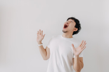 Wow face of ordinary Asian man in white t-shirt isolated on white background.