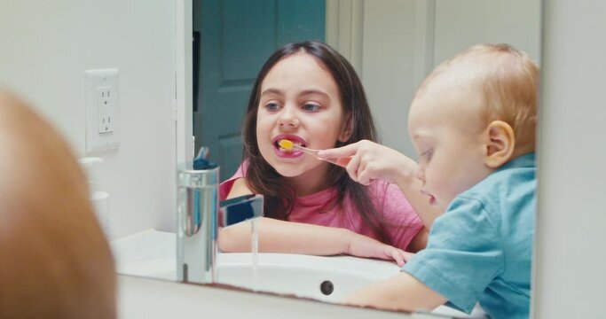 Two Children A Girl And A Boy Brushing Their Teeth In The Bathroom