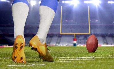 American football player kicking ball in close up.