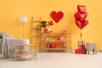 Interior of festive living room with wooden shelving unit and decorations for Valentine's Day...