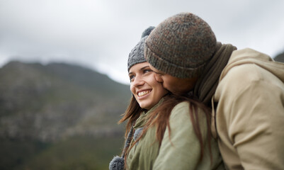 Couple, kiss and love on hike in nature together, bonding and romance in outdoors on mountain. Winter, people and security and connection in relationship or marriage, holiday and trekking adventure