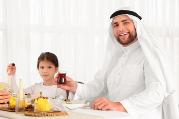 Young Muslim man having family dinner at home. Ramadan celebration