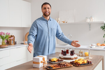 Fototapeta na wymiar Young Muslim man celebrating Ramadan at table in kitchen