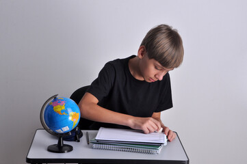 estudante garoto fazendo tarefas escolares em carteira na escola 