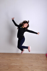 garota pré adolescente feliz e sorridente pulando de alegria 