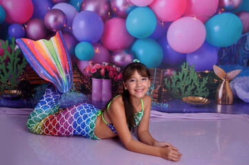 menina sorridente com roupa de sereia em cenário fundo do mar, ensaio de aniversário temático...