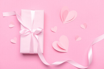Obraz na płótnie Canvas Composition with gift box and paper hearts for Valentine's Day celebration on pink background
