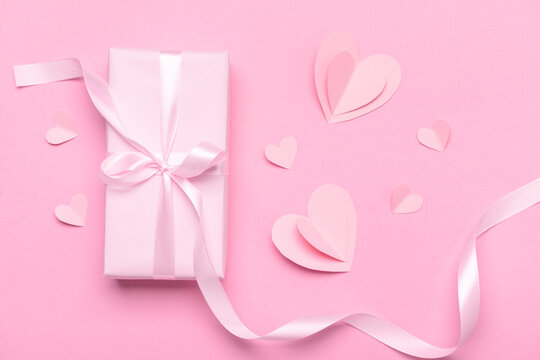 Composition with gift box and paper hearts for Valentine's Day celebration on pink background © Pixel-Shot