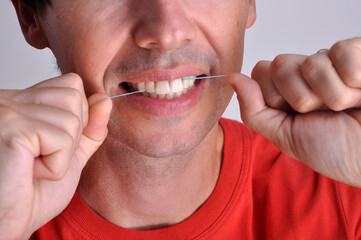 homem passando fio dental nos dentes , limpeza dental 